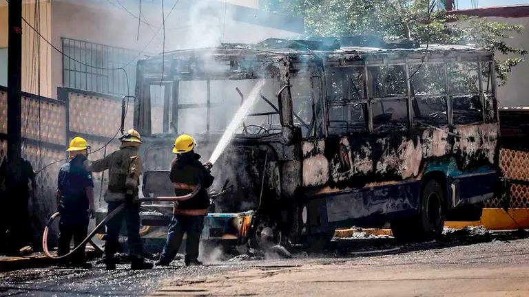 Bomberos controlan el incendio de un autobús hoy en el balneario de Acapulco, estado de Guerrero (México). EFE