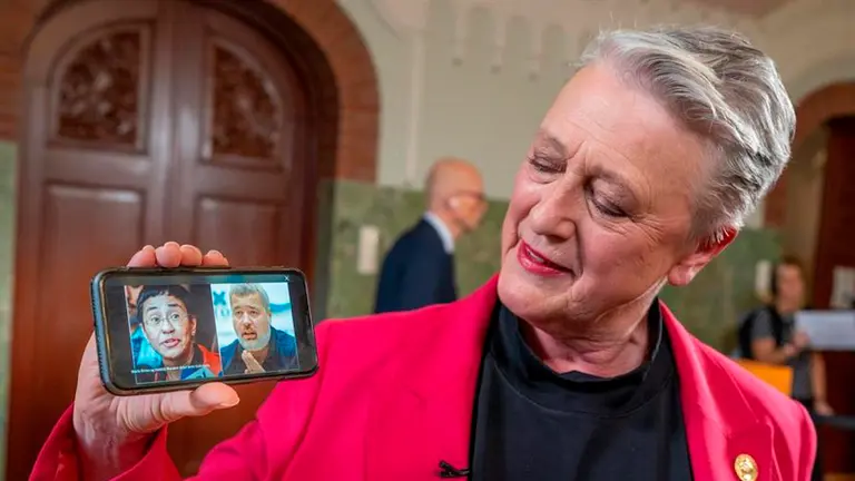 Premio Nobel de la Paz, Berit Reiss-Andersen, muestra en un m&oacute;vil a los dos ganadores del Nobel de la Paz Maria Ressa y Dmitry Muratov, tras el anuncio celebrado este viernes en Oslo.