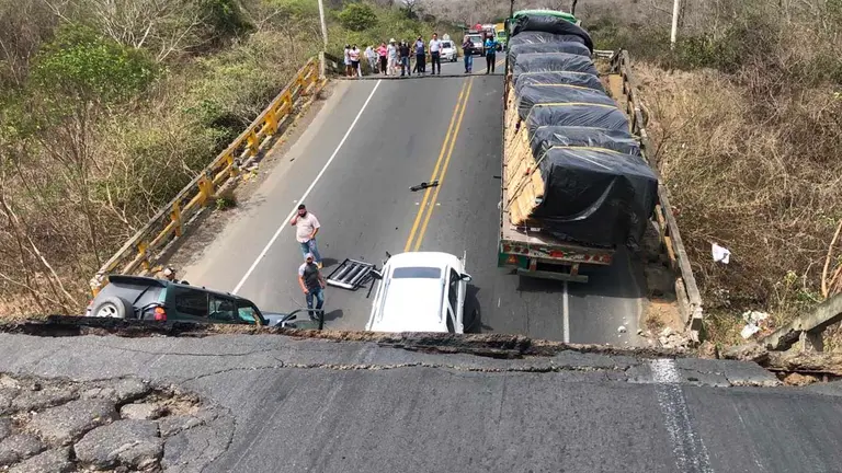 Fotografía cedida por el Servicio de emergencias Ecuador -911 de tres vehículos que quedaron atrapados hoy al derrumbarse un puente en una carretera que une las localidades de Montecristi y Jipijapa, en la provincia costera de Manabí.EFE