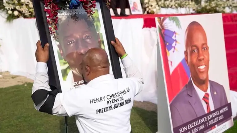 Imagen de archivo de un hombre que besa una imagen del presidente Jovenel Moise durante su ceremonia fúnebre en Cap-Haitien (Haití). EFE