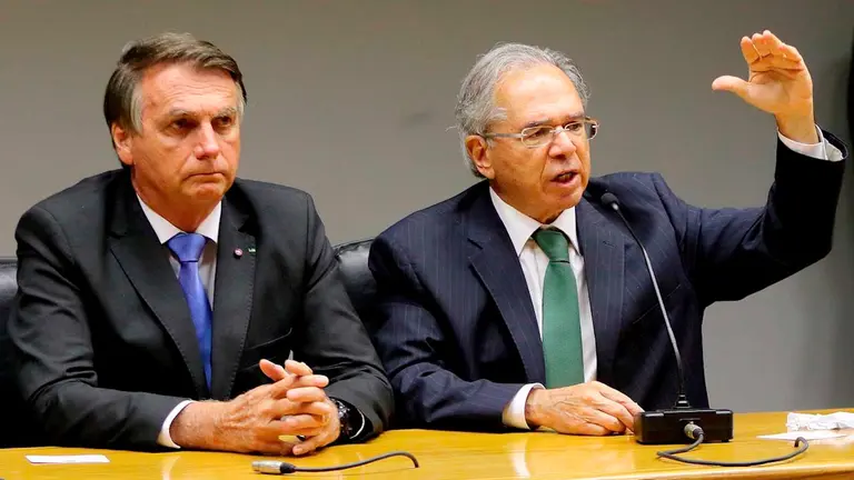Fotografía cedida hoy por la Agencia Brasil que muestra al presidente brasileño Jair Bolsonaro (i) y al ministro de Economía, Paulo Guedes, mientras participan de una rueda de prensa en Brasilia (Brasil). EFE