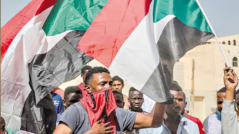 Sudaneses protestas en la capital de Jartum portando banderas nacionales de su país.   EFE