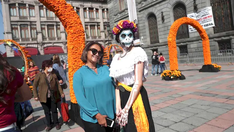 Personas posan frente a la ofrenda instalada en la Plaza Manuel Tolsá hoy, en el Centro Histórico de la Ciudad de México (México). EFE