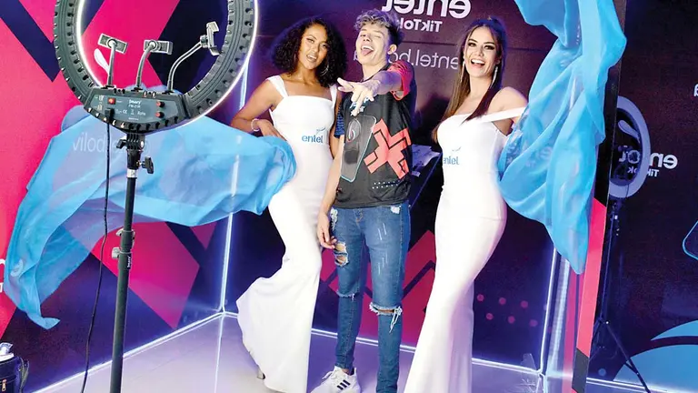 Azafatas y un tiktoker que engalanan el stand de Entel. DICO SOLÍS