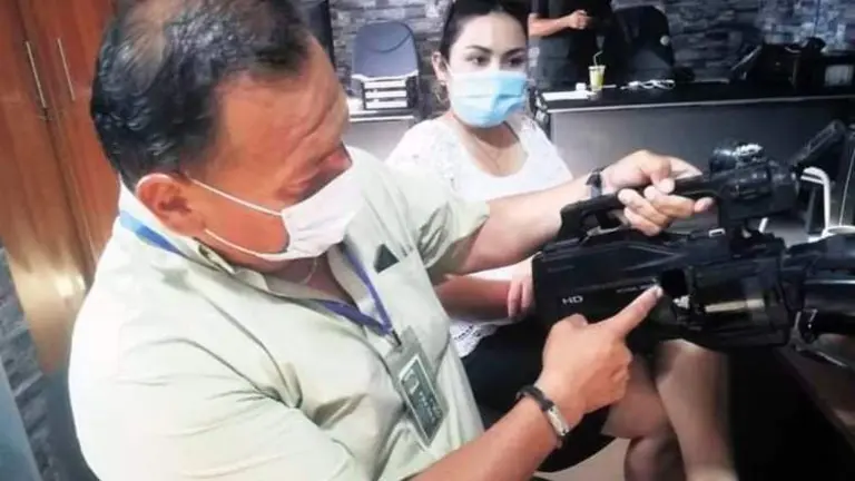 El camar&oacute;grafo de ATB Percy Su&aacute;rez muestra el impacto de bala en su c&aacute;mara. El Deber