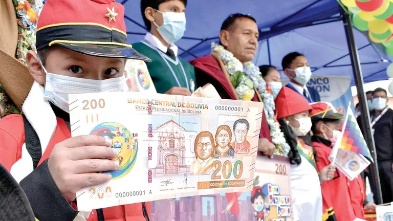 Niño muestra los 200 bolivianos del bono Juancito Pinto que se entrega a los estudiantes. APG