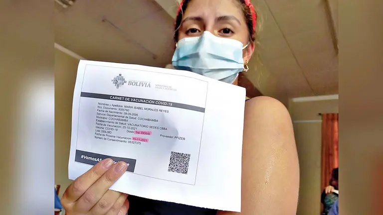 Una mujer muestra su carnet de vacunación contra la COVID. DICO SOLÍS