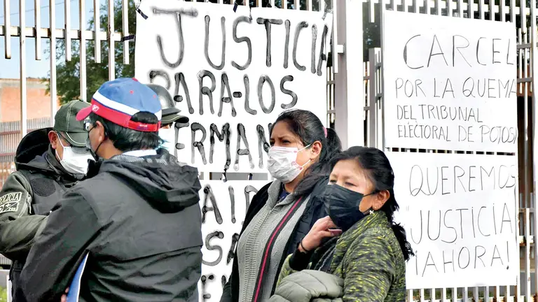 Familiares de Marco Pumari frente al Edificio Judicial de Llallagua donde pusieron carteles a favor y en contra.        APG