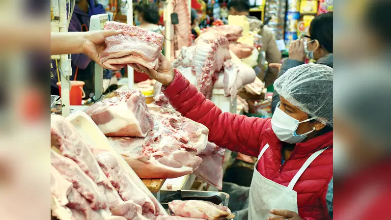 Una mujer compra carne de cerdo en un mercado. DICO SOLÍS