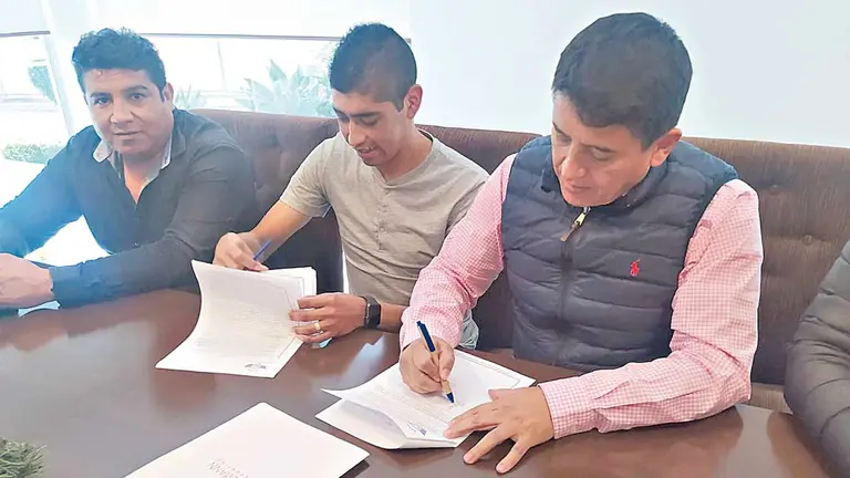 Raúl Castro (c) firma su contrato junto al titular del Rojo Gróver Vargas (d). ARIEL GUZMÁN