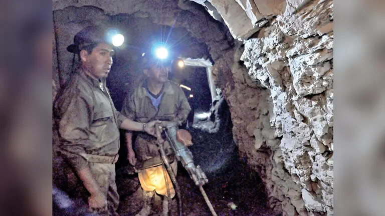 Dos mineros trabajan al interior de un socavón.  ARCHIVO
