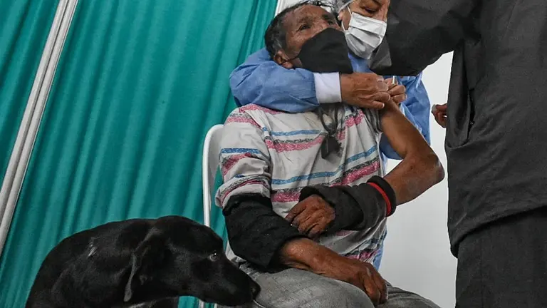 Paulino recibe la primera dosis de la vacuna contra la COVID-19, en compañía de uno de sus perritos. DICO SOLÍS