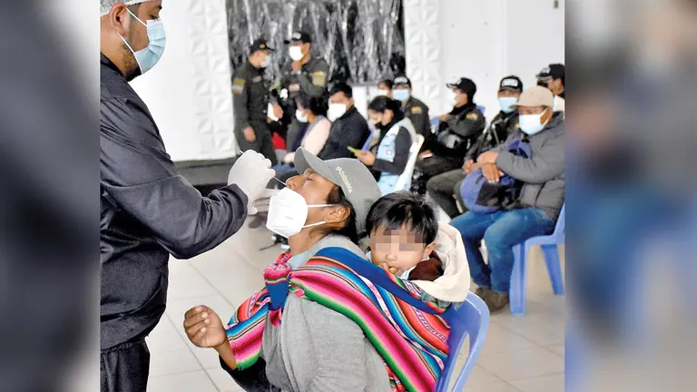 Un médico hace una prueba de antígeno nasal a mujer que está con su bebé. DICO SOLÍS