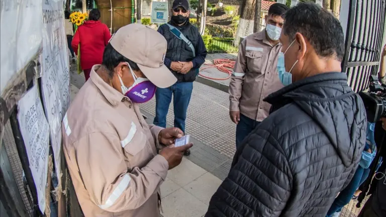 Un trabajador del Cementerio General controla que la poblaci&oacute;n porte carnet de vacunaci&oacute;n anticovid para ingresar. GAMC