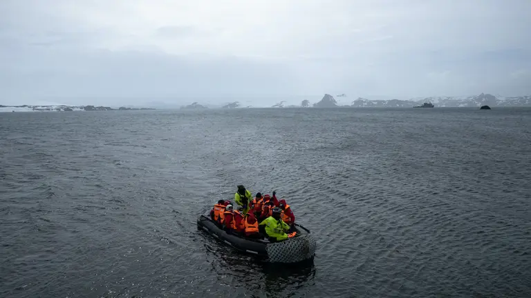Un grupo de estudiantes chilenos con personal de la base profesor Julio Escudero son vistos mientras recorren en lancha la bah&Igrave;a de Fildes, situada en Isla Rey Jorge en la Ant&middot;rtida chilena, el pasado 17 de diciembre de 2021. EFE/ Alberto Vald&Egrave;s
