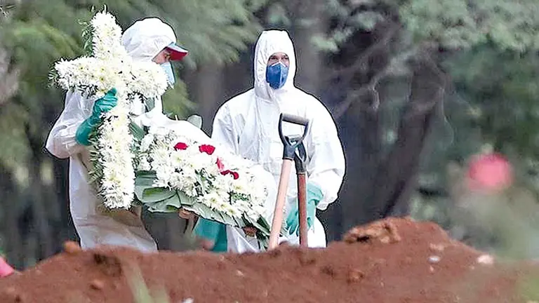 Empleados del servicio funerario entierran a una víctima de COVID-19 en el cementerio de Vila Formosa, en Sao Paulo. ARCHIVO