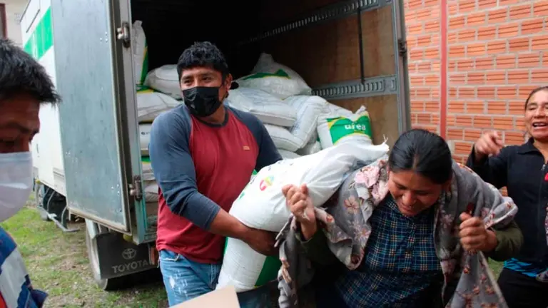Comunarios damnificados por granizadas recogen bolsas de urea. GAMQ