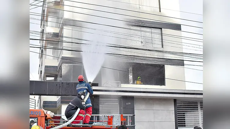 Bomberos y grupos de rescate sofocan el incendio. RUBÉN RODRÍGUEZ