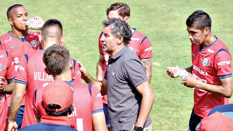 El técnico de Wilster, Miguel Ponce (c), conversa con los jugadores en la cancha. DICO SOLÍS