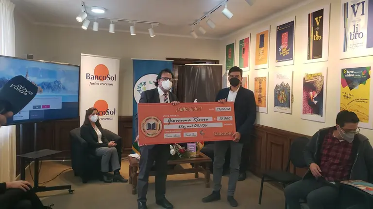 El Presidente de la C&aacute;mara del Libro de La Paz le entrega un cheque al editor Fernando Barrientos.    EL CUERVO