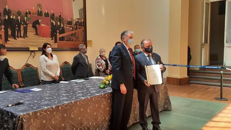 El senador Fernando Denhe (i) entrega el reconocimiento camaral al gobernador de Rotary, &Aacute;ngel D&iacute;az.
