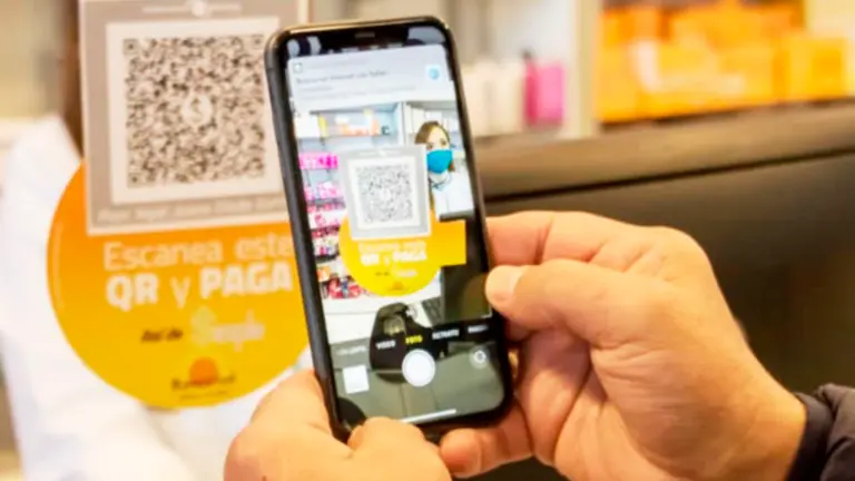 Una persona utilizando un c&oacute;digo QR para realizar una transferencia. BITEVOLUCI&Oacute;N