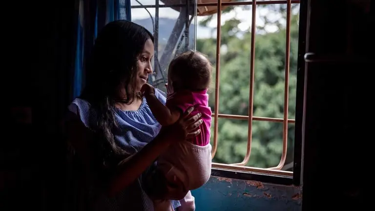 Yorianny Iriarte, de 18 a&ntilde;os, sostiene a su hija Zo&eacute; Hidalgo, de 5 meses, en Caracas.             EFE
