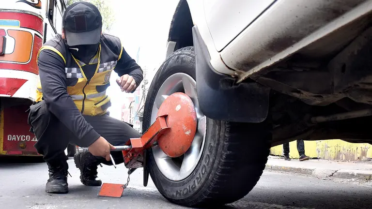 Un funcionario del SEM retira una grapa de un veh&iacute;culo.  Dico Sol&iacute;s