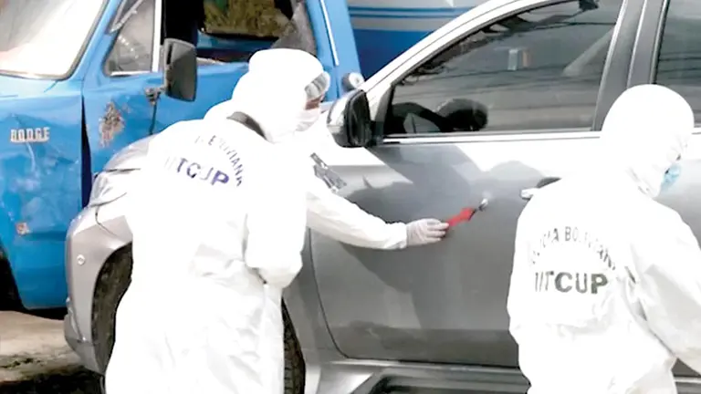 Personal del IITCUP observa uno de los impactos en la camioneta de Orlando Q., asesinado en Sacaba. RED UNO