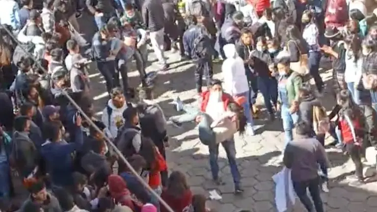 Un estudiante auxilia a una compa&ntilde;era, tras la estampida en Potos&iacute;.
