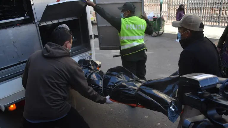 El momento en que oficiales proceden al levantamiento del cad&aacute;ver del hombre victimado con arma de fuego, en la calle Uruguay casi Lanza. DICO SOL&Iacute;S