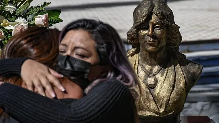 Mujeres se abrazan y recuerdan a Rayza Torriani. De fondo, el busto dedicado en memoria de la activista. DICO SOL&Iacute;S