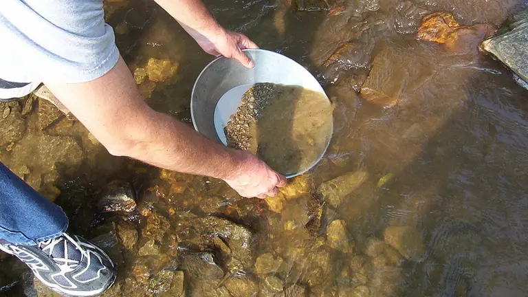 Imagen referencial de la extracci&oacute;n de oro en un r&iacute;o.