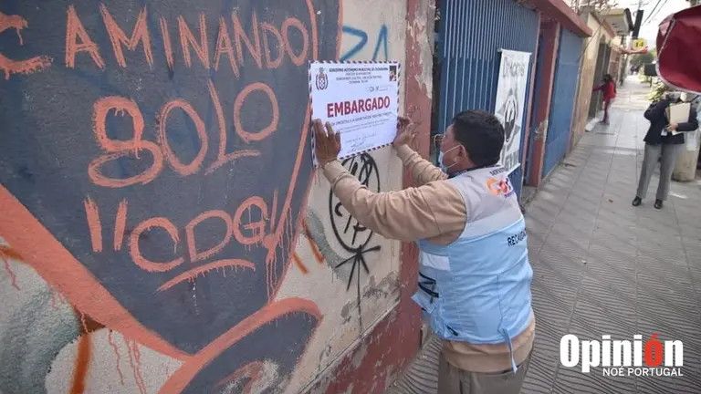 Personal municipal coloca el letrero de embargo en una propiedad en la avenida Aniceto Padilla, este 1 de junio. NOÉ PORTUGAL