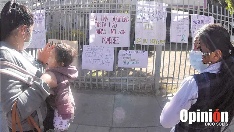 Familia observa los carteles pegados por activistas en puertas del Maternológico. DICO SOLÍS 