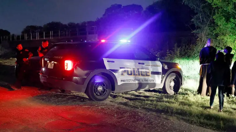Fotografía tomada el pasado 28 de junio en la que que registró a un grupo de policías en la carretera donde hallaron un camión con decenas de inmigrantes ilegales que muirieron en su interior, en San Antonio (Texas, EEUU). EFE