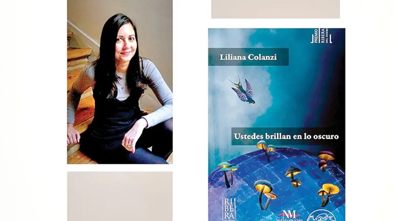 La escritora boliviana Liliana Colanzi, retratada en marzo de 2022, en Madrid, junto a la portada de la edición boliviana de &lsquo;Ustedes brillan en lo oscuro&rsquo;. AITOR SOL