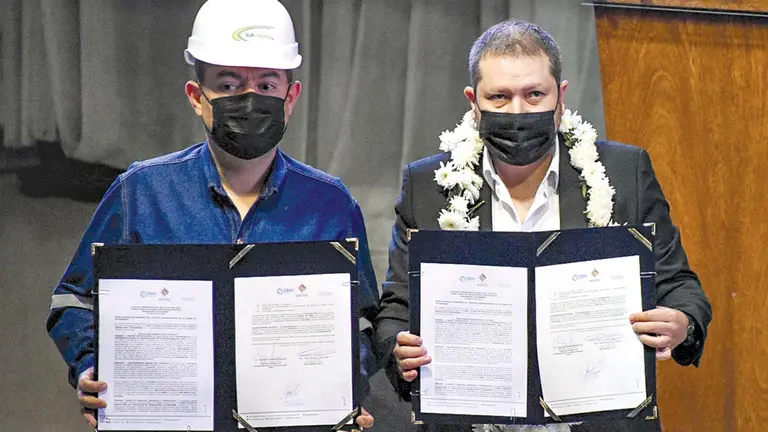 El gerente interino de la EBIH, Alejandro Gallardo, (derecha) y el representante de la empresa Sur Energy, Carlos Zilveti, (izquierda) muestran el contrato firmado para la construcción de la planta de fertilizantes. DICO SOLÍS