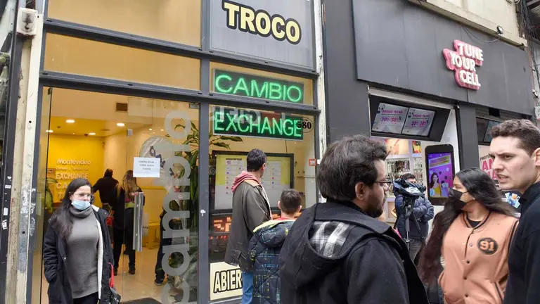 Transeúntes caminan afuera de una casa de cambio, hoy, en Buenos Aires (Argentina). EFE