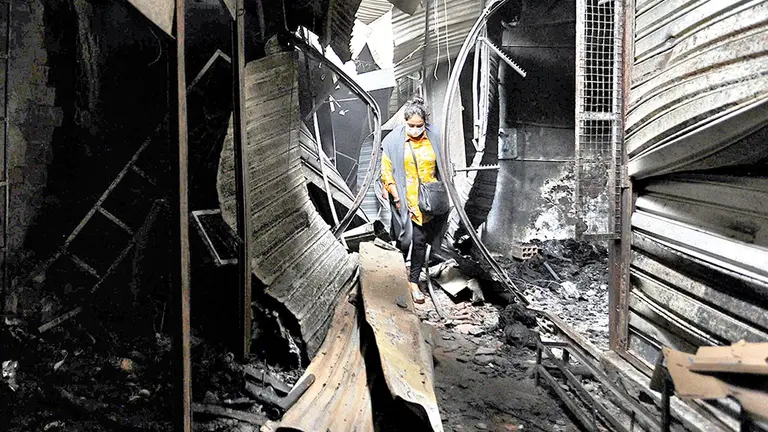 Una mujer recorre las casetas afectadas por el incendio. APG