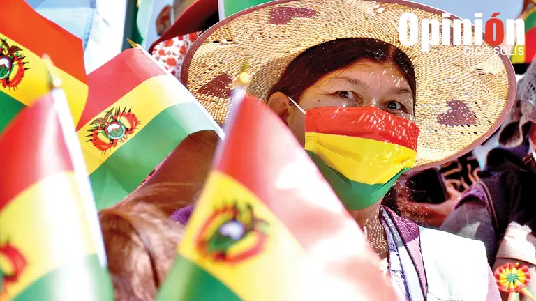 Una mujer hace flamear la bandera boliviana. DICO SOL&Iacute;S
