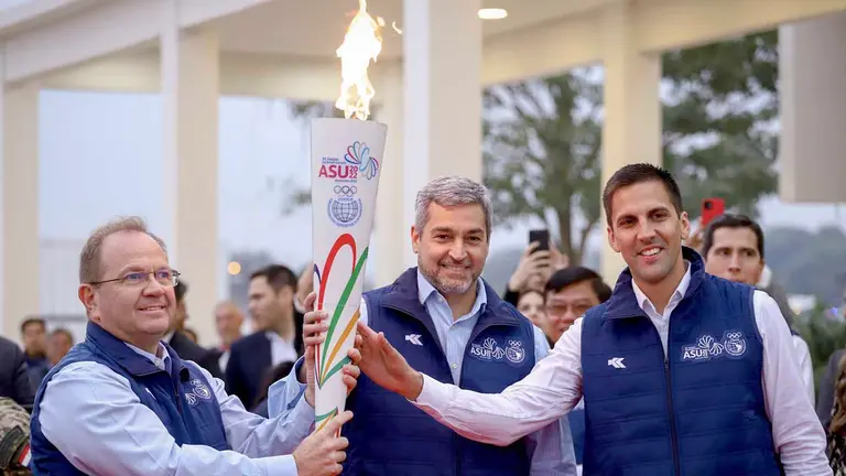 Camilo Pérez López M.(i), presidente del Comité Olímpico Paraguayo; Mario Abdo Benítez (c), presidente de Paraguay, y Diego Galeano H., ministro de Deportes, posan con la antorcha de los XII Juegos Suramericanos en Luque (Paraguay). EFE