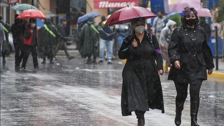 Dos mujeres transitan por el centro de la ciudad en medio de la lluvia. DICO SOL&Iacute;S