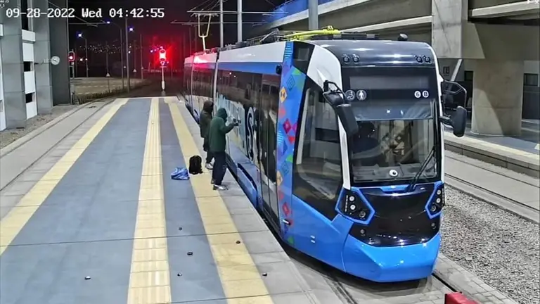 Dos encapuchados grafitean un vag&oacute;n del tren. TREN METROPOLITANO