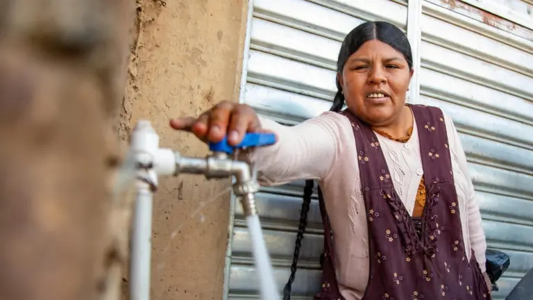 Una de las vecinas de la OTB Alto Nueva Esperanza abre una pileta, tras la inauguraci&oacute;n del servicio de agua en dicha zona. ALCALD&Iacute;A DE COCHABAMBA