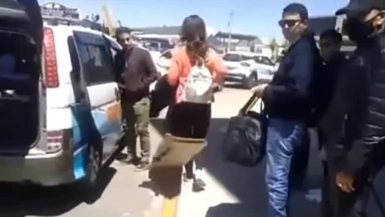El periodista Pablo Fern&aacute;ndez parado junto al veh&iacute;culo de transporte p&uacute;blico, la periodista Nicole Rossell y otros integrantes del equipo de televisi&oacute;n Tigo.   RRSS