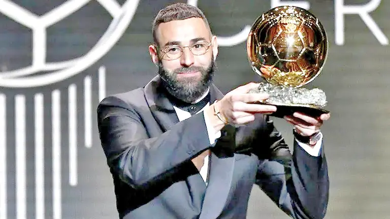 Karim Benzema expone el premio que recibi&oacute; en Par&iacute;s por parte de France Football. TYCSPORTS.COM