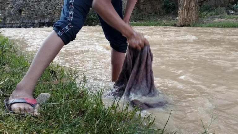 La ropa es lavada en la corriente del rio para el agua se lleve todas las penas del difunto y de su familia. MARIA EUGENIA CONDORI.