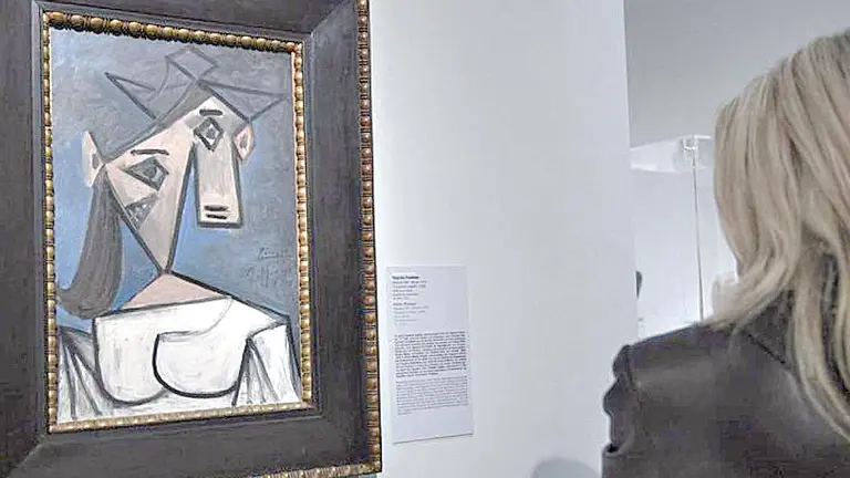 Una mujer ve la pintura &ldquo;Cabeza de mujer&rdquo;, de Picasso. P&Uacute;BLICO
