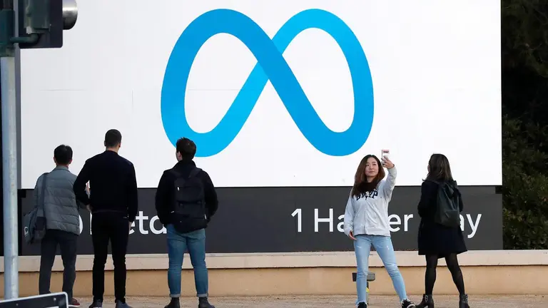 Personas posan frente al cartel de Meta en la sede de la tecnológica estadounidense Meta en Menlo Park, California (EEUU). EFE